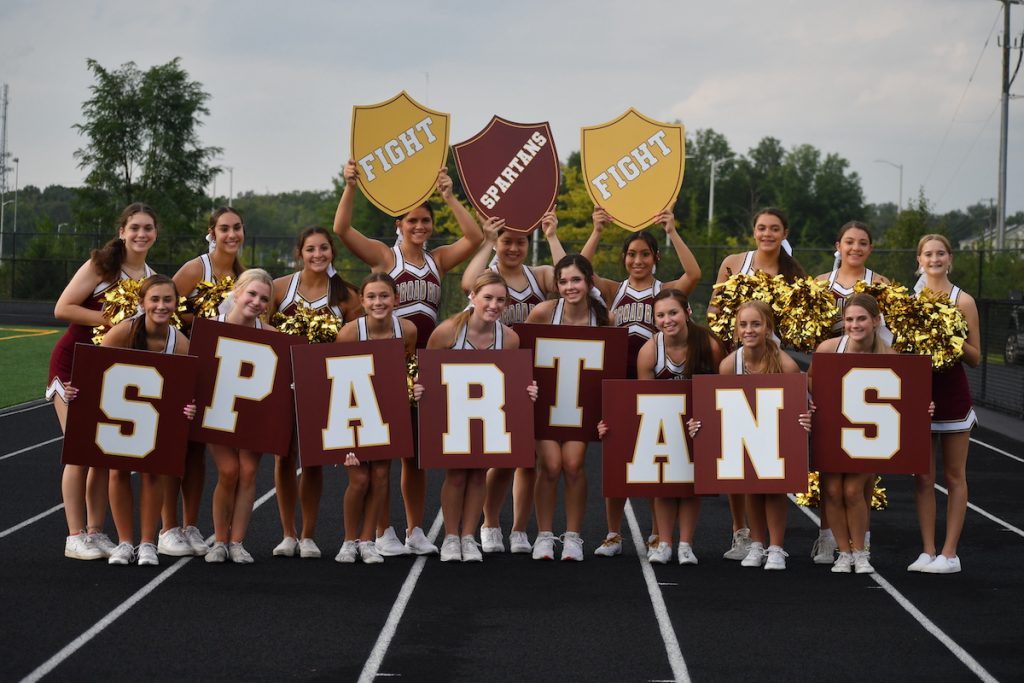 Broad Run High School cheerleaders holding cheerleading signs with text that say "Fight" and "Spartans"