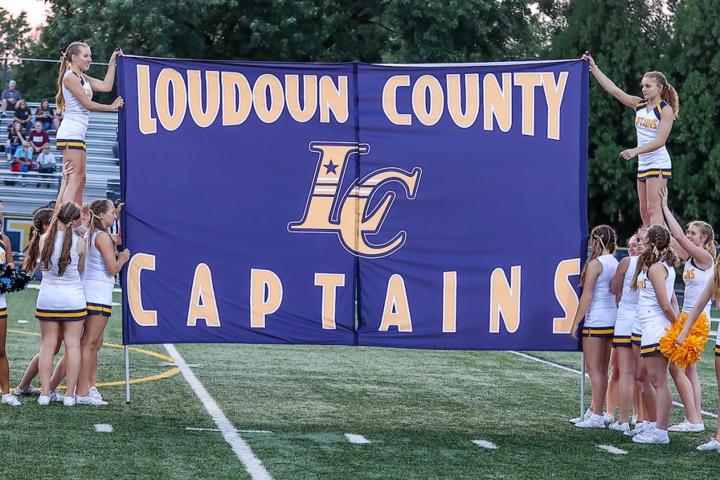 Loudoun County High School cheerleaders holding up breakaway banner